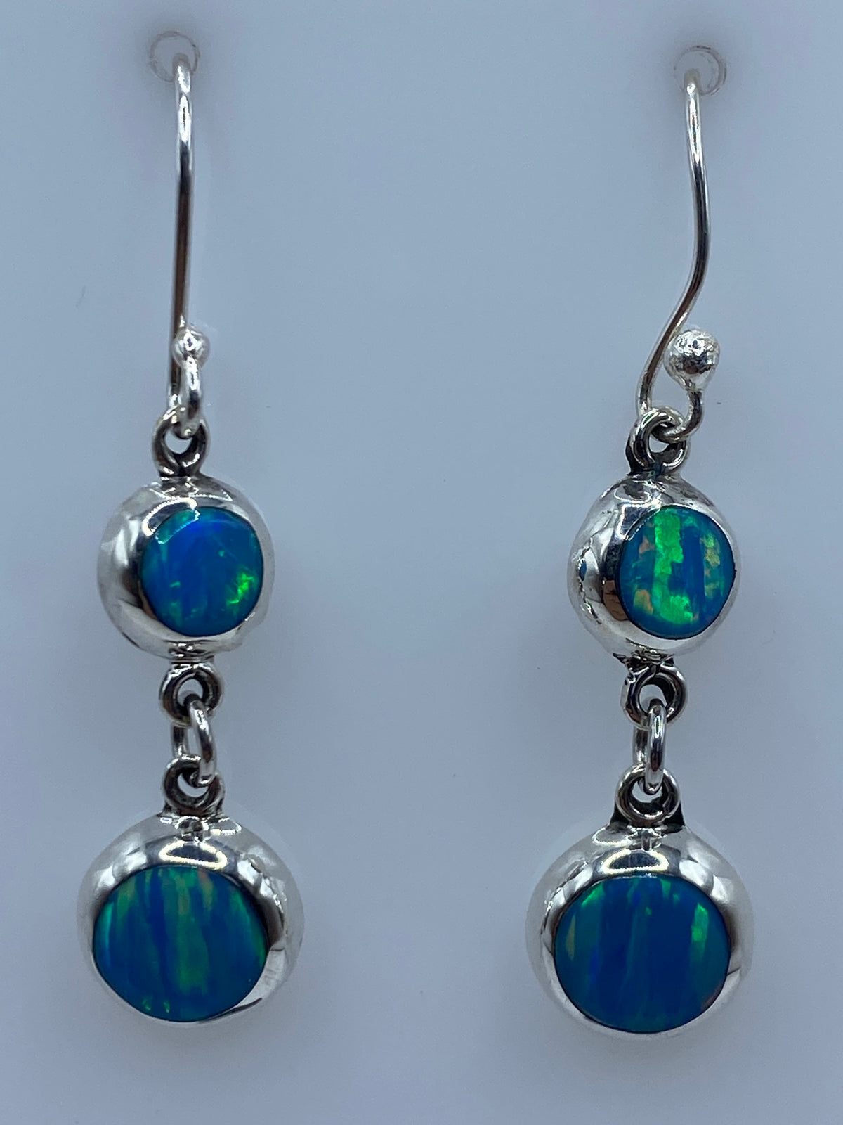 Aretes de plata junto a regla de centímetros mostrando largo de 3.9 cm