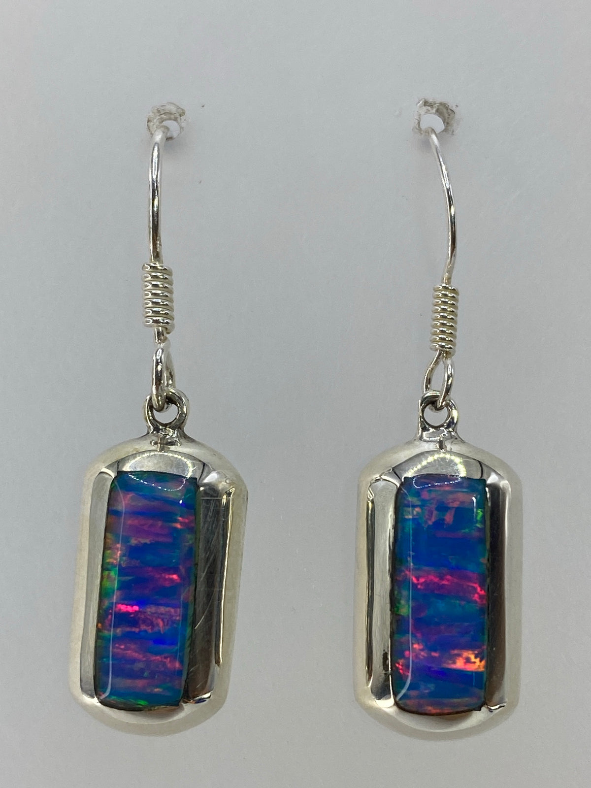 Par de aretes de plata con ópalo de fuego multicolor — rojo, naranja, azul y verde en juego de luz