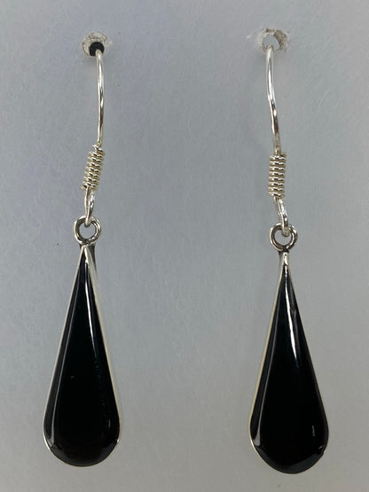 Par de aretes de onix negro vistos con regla de centímetros para escala