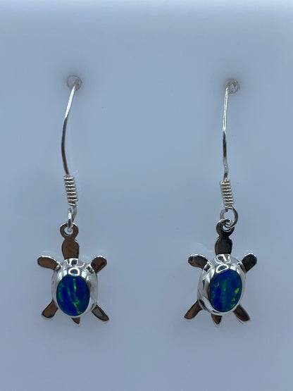 Detalle frontal de los aretes mostrando el Ópalo de Fuego azul engastado en plata 925