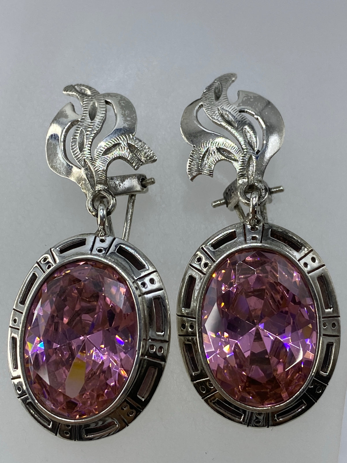 Aretes de plata circonia rosa juntos sobre fondo gris, largo 4 cm