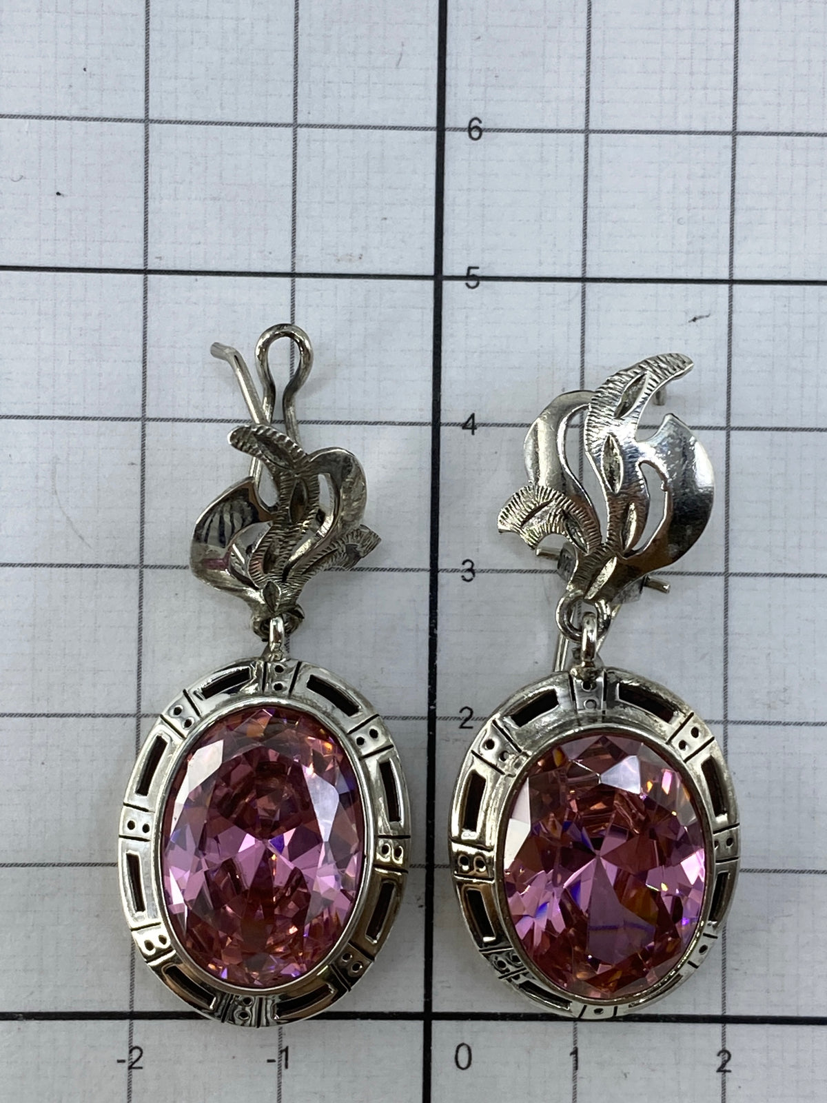 Cercanos los dos aretes de Taxco con reflejo de luz en la circonia rosa