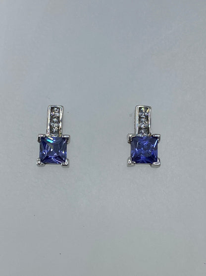 Detalle frontal de los aretes mostrando la circonia azul y el brillo de la plata