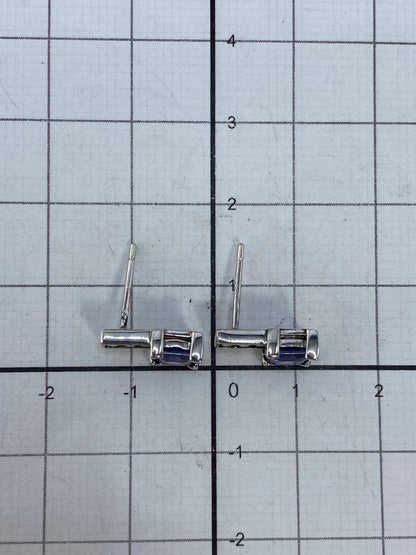 Aretes de plata sobre tela azul mostrando el reflejo de la piedra