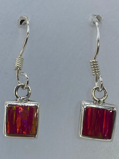 Aretes colgando mostrando el reflejo iridiscente del ópalo rosa
