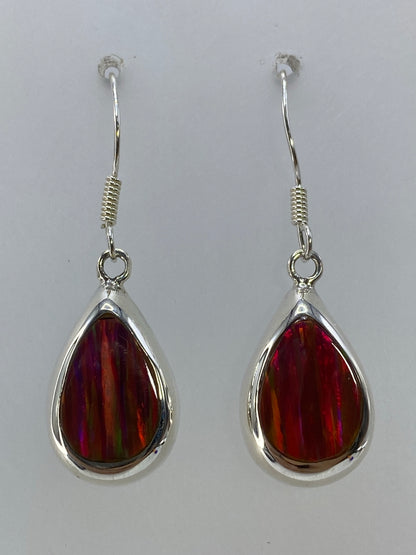 Par de aretes de plata con ópalo de fuego multicolor, largos 3.8 cm, colgando sobre fondo blanco