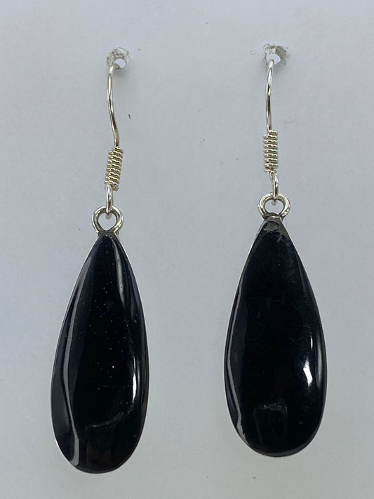 Par de aretes de plata en forma de gota con piedra negra, vistos de frente