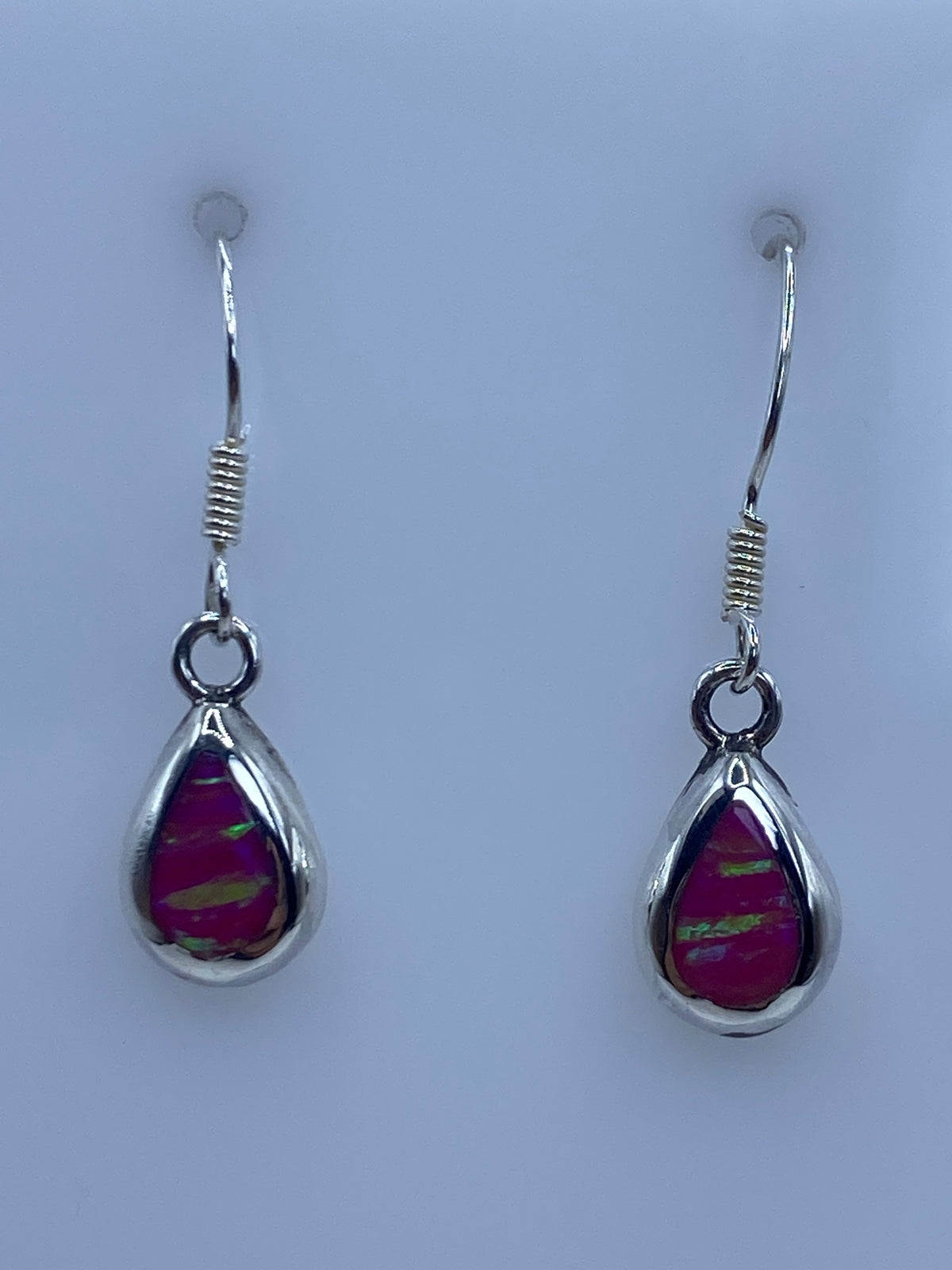 Par de aretes de plata 950 con ópalo de fuego rosa, detalle frontal mostrando el brillo y los reflejos
