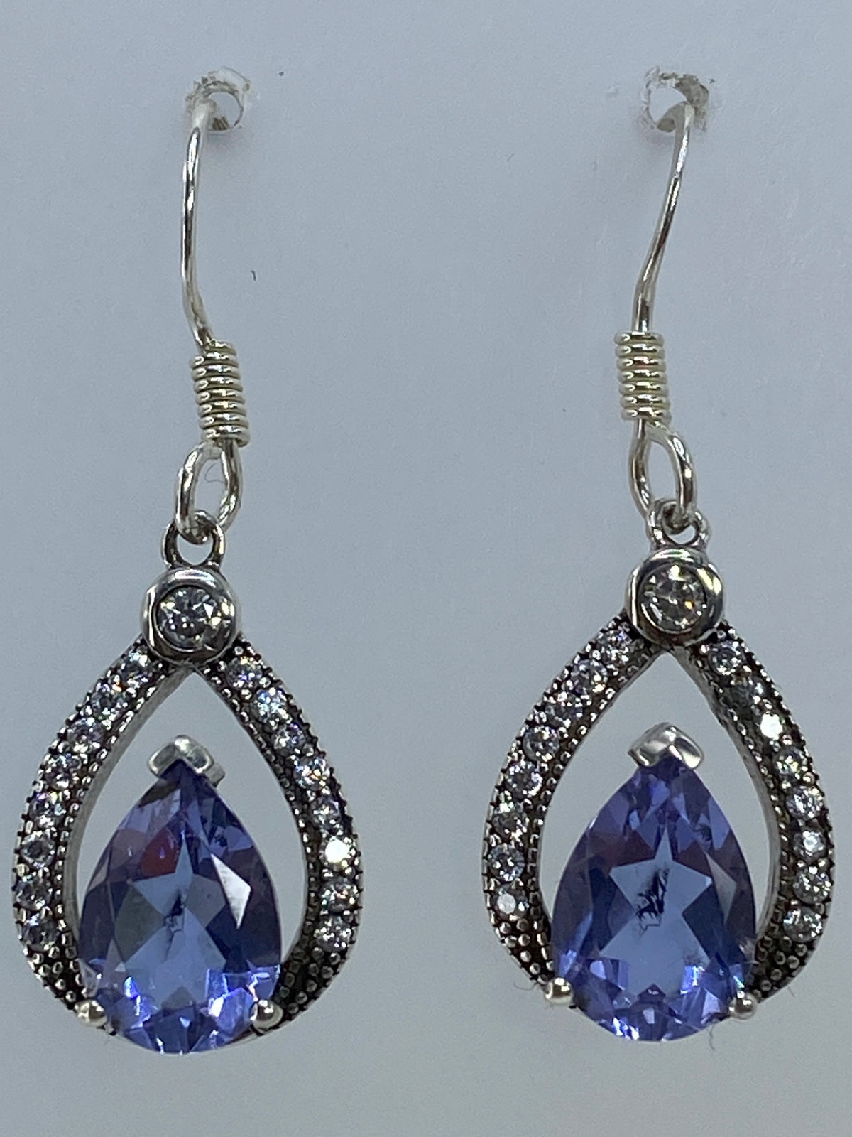 Aretes gota sobre fondo blanco mostrando el brillo de la piedra
