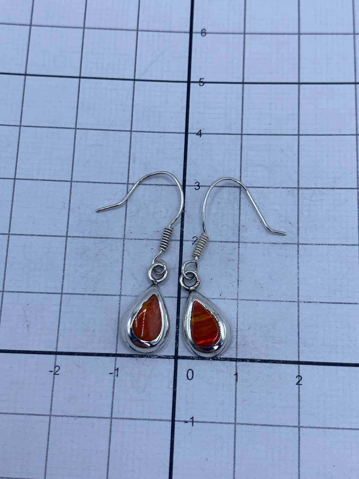 Aretes sobre escala digital mostrando peso de 1.4 gramos total