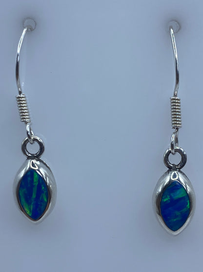 Detalle de uno de los aretes mostrando el ópalo de fuego azul engastado en plata