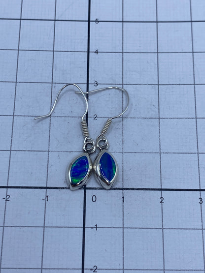 Aretes de plata 950 con ópalo de fuego sobre fondo neutro, con Quinto visible