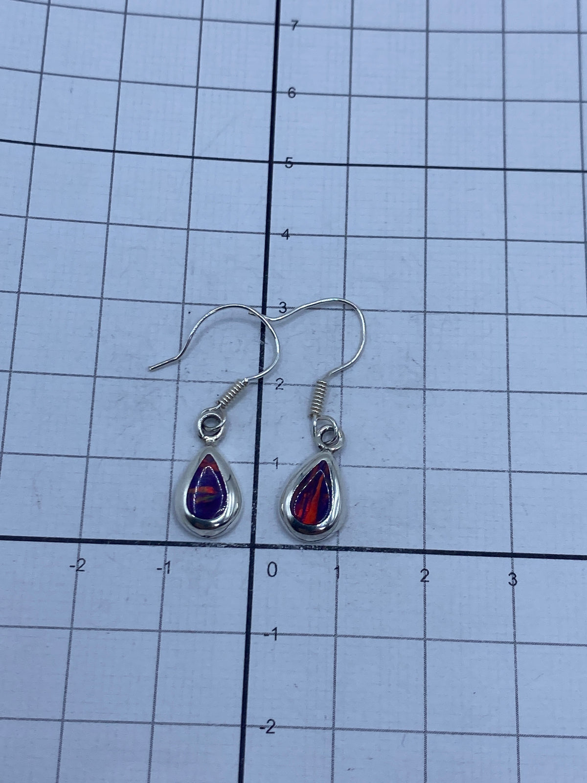 Aretes de ópalo vistos desde arriba sobre fondo gris — juego de colores vivos