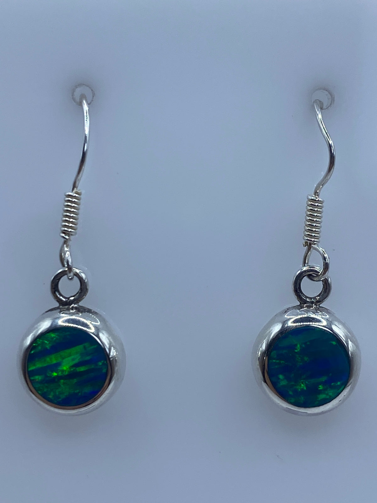 Par de aretes de plata con ópalo de fuego azul en vista frontal