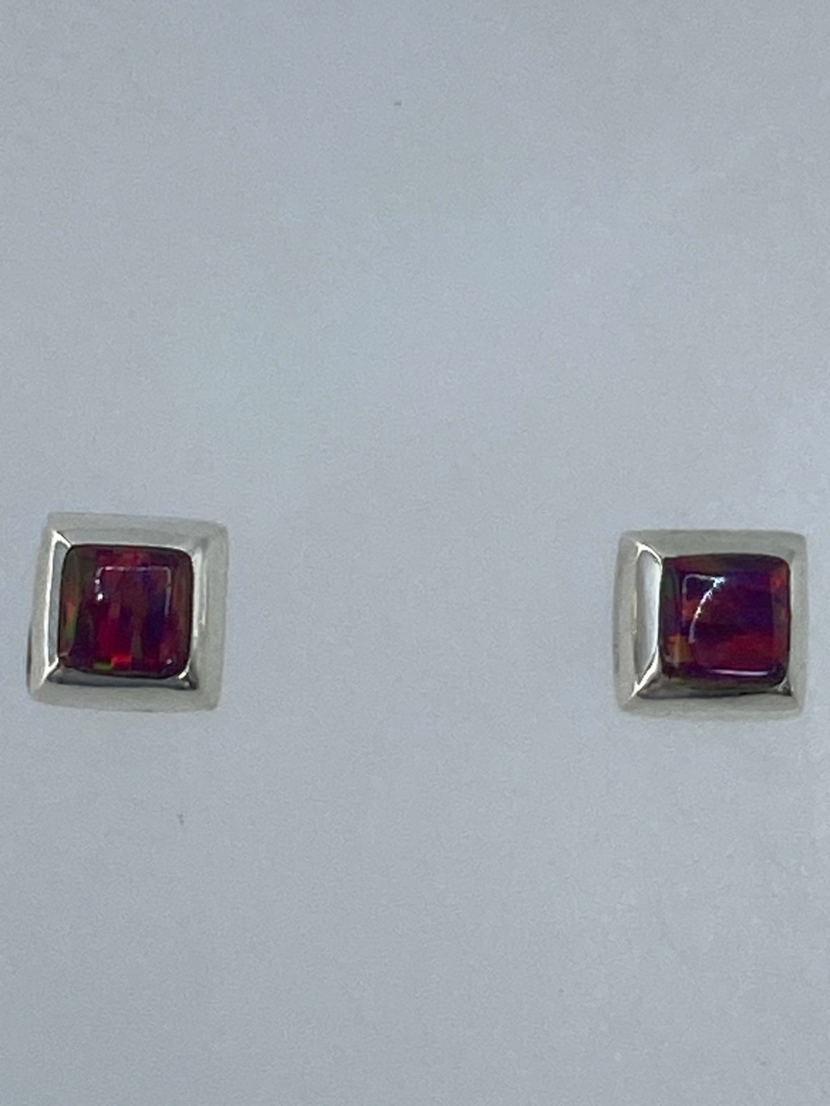 Aretes de plata 925 con ópalo de fuego multicolor engastados a mano, sobre fondo blanco