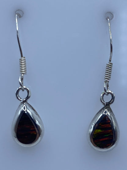 Par de aretes de plata con ópalo de fuego multicolor sobre fondo blanco