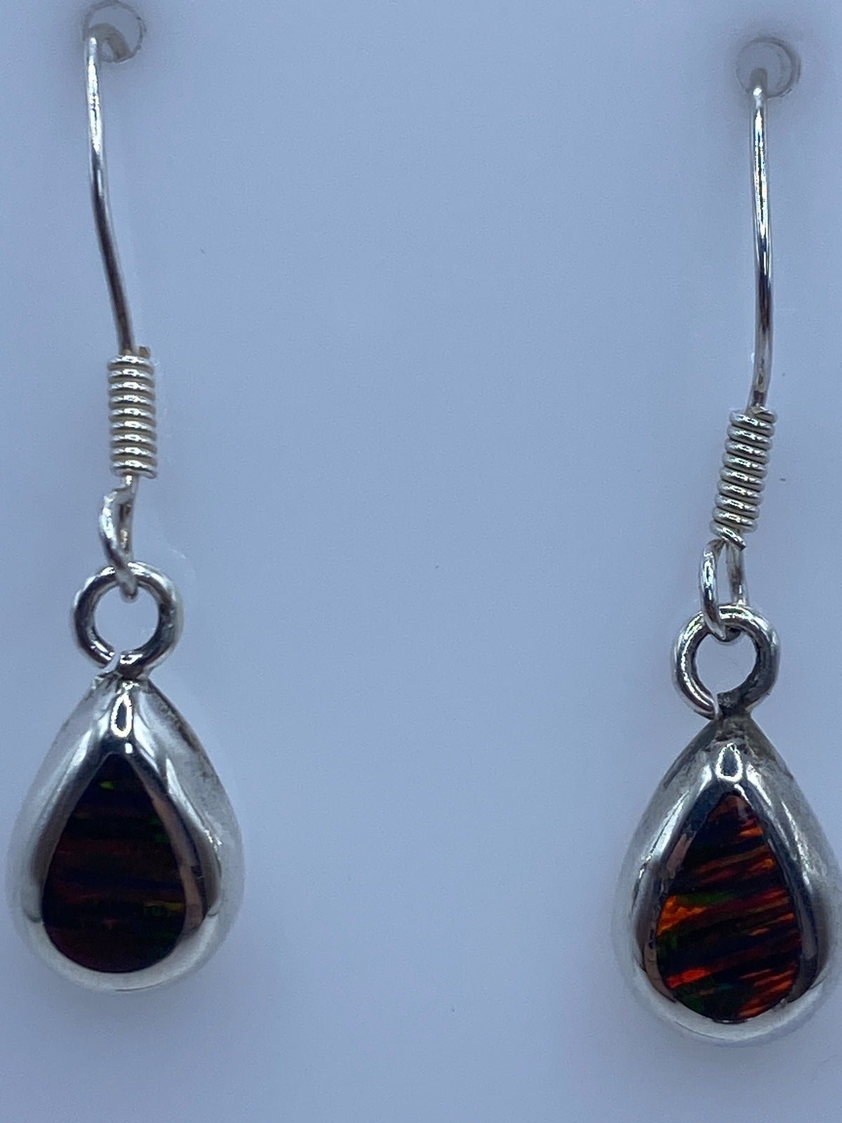 Aretes en uso, mostrando los colores del ópalo bajo la luz natural