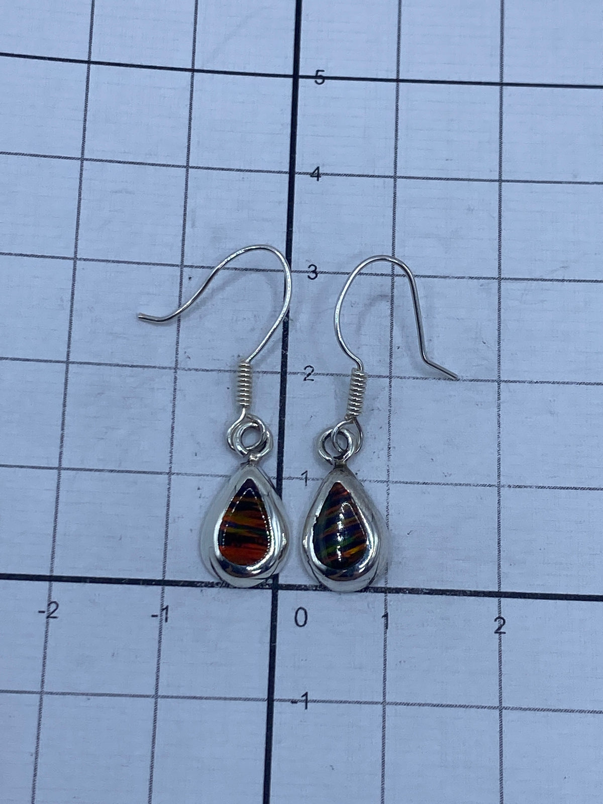 Vista frontal de los dos aretes alineados, ópalo de fuego multicolor