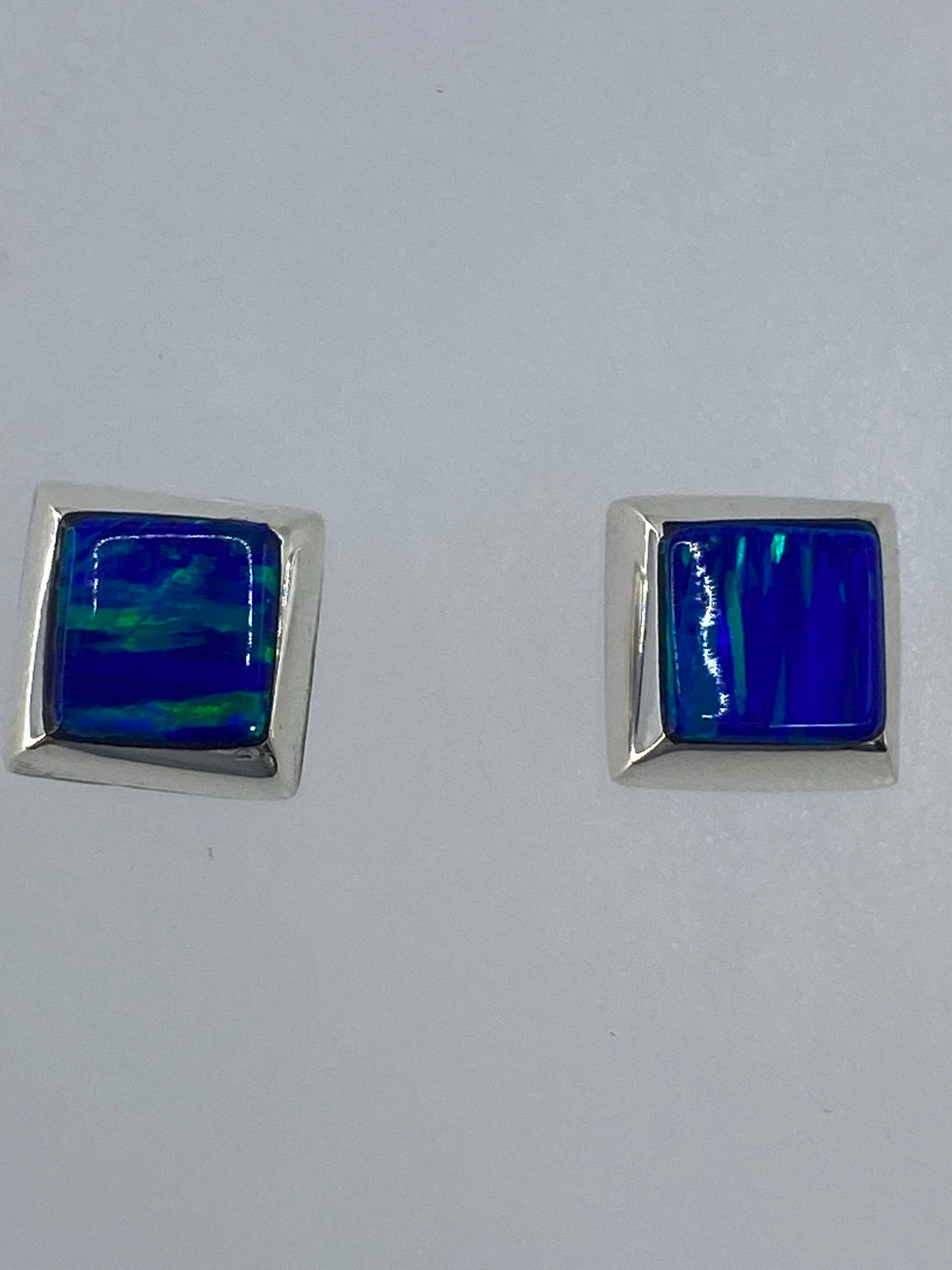 Detalle del ópalo de fuego en los aretes mostrando reflejos de naranja y verde