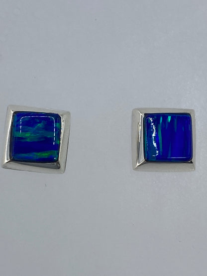 Detalle del ópalo de fuego en los aretes mostrando reflejos de naranja y verde