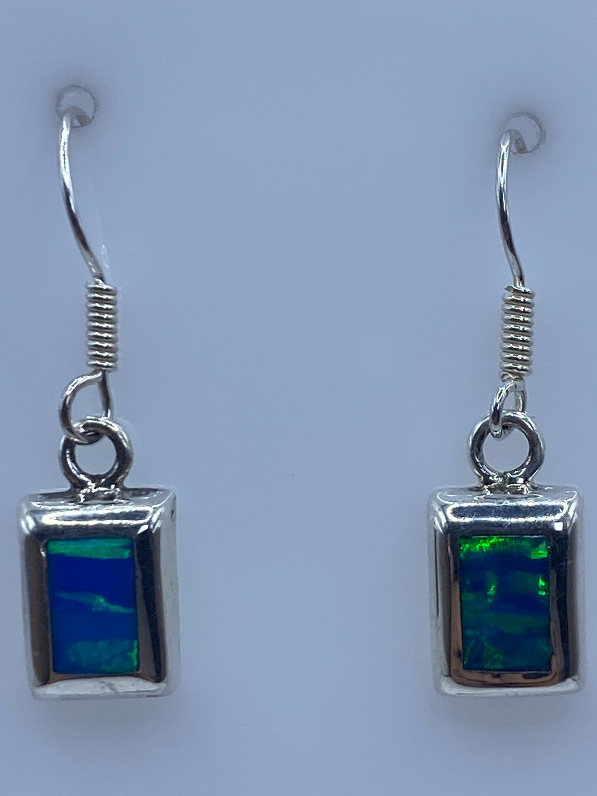 Aretes sobre regla de centímetros mostrando largo de 2.9 cm