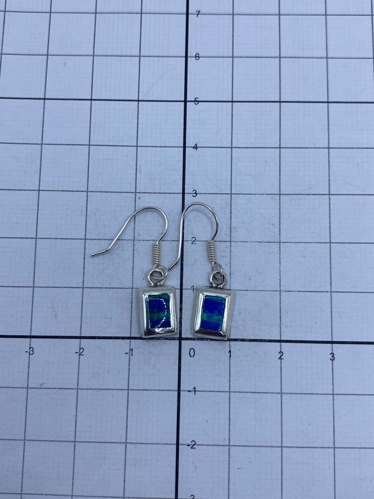 Aretes de plata con ópalo de fuego, mostrando el Quinto 925 grabado
