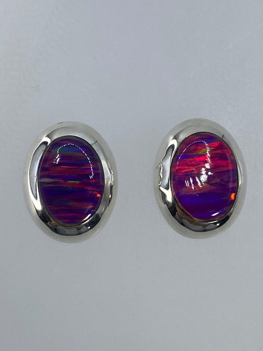 Par de aretes de plata 925 con ópalo de fuego multicolor, vistos de frente mostrando el color iridiscente