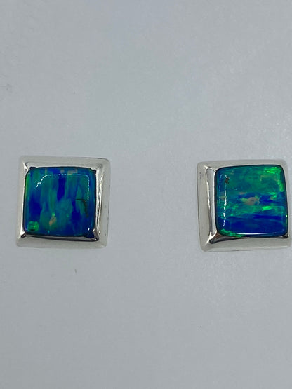 Detalle frontal de los aretes mostrando el brillo y color del ópalo de fuego
