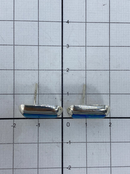 Par de aretes sobre regla milimétrica mostrando el tamaño de 1.4 cm