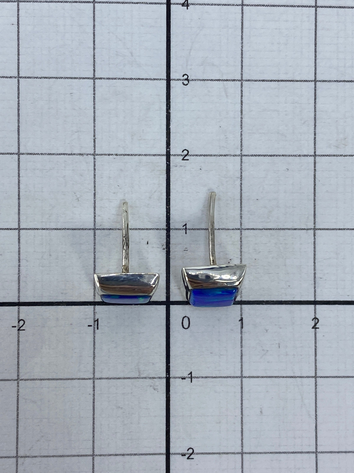 Aretes sobre fondo neutro con sello 925 visible en la plata