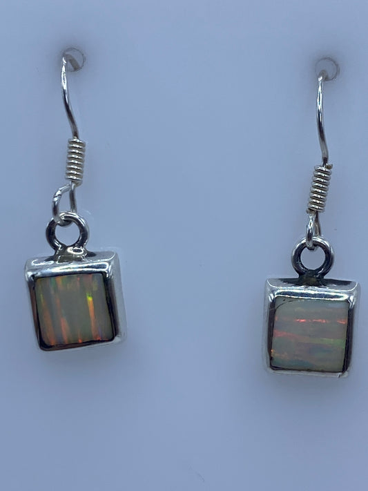 Par de aretes de plata con ópalo de fuego multicolor engastado, colgando de gancho de plata