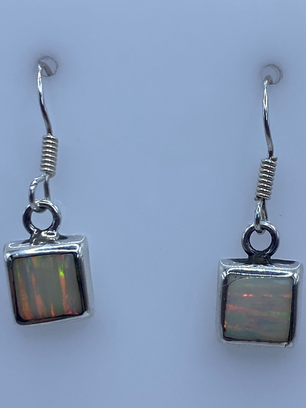 Aretes de plata 925 sobre fondo blanco con marca del Quinto visible