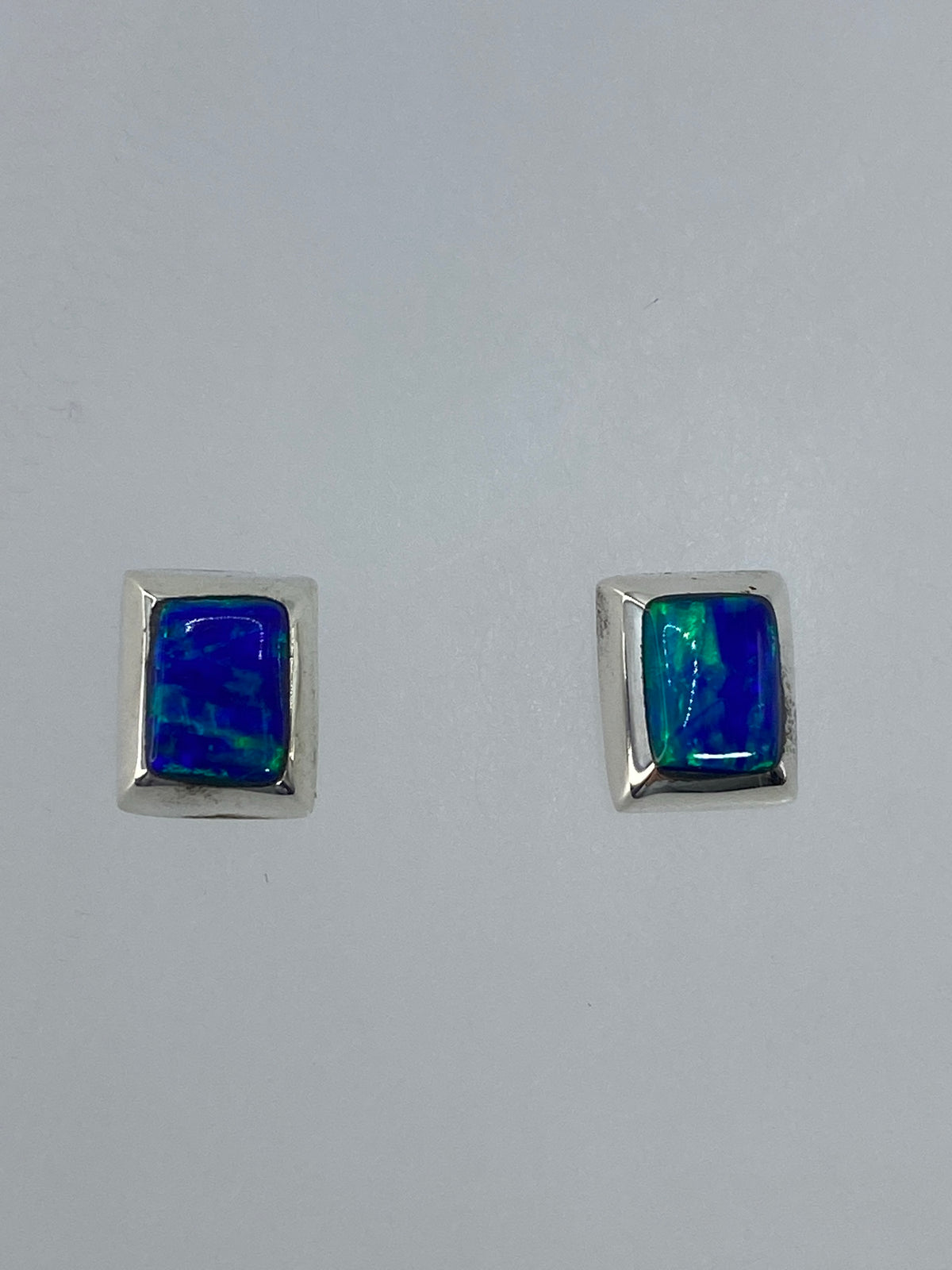 Detalle cercano de un arete mostrando el engaste artesanal de la piedra en plata pura