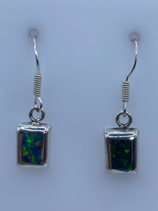 Par de aretes de plata con ópalo de fuego verde colgando del gancho