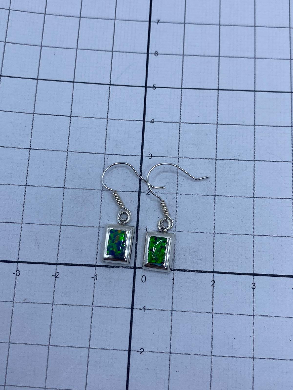 Aretes de ópalo verde en plata 925 sobre fondo oscuro