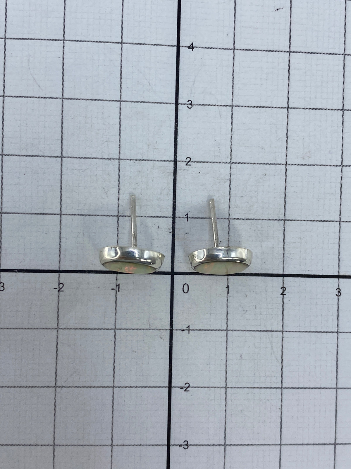 Aretes sobre fondo blanco mostrando el Quinto 925 y tamaño delicado de 1.3 cm