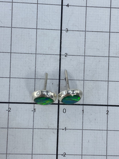 Aretes de ópalo de fuego sobre escala de medida, largo 13 cm