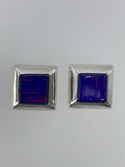 Aretes de plata engastados a mano, detalle del ópalo de fuego con destellos naranja y rojo