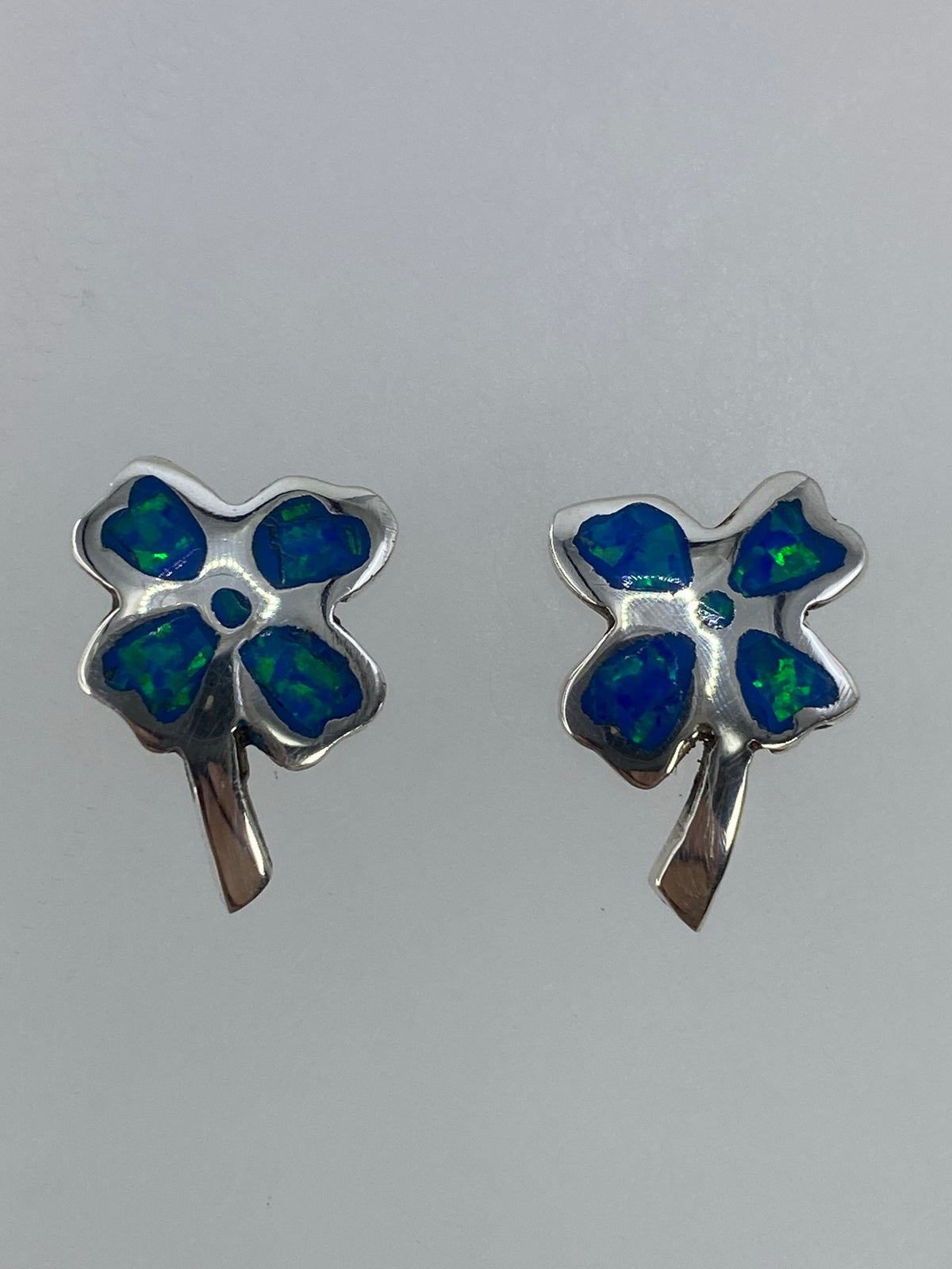 Detalle frontal de ambos aretes mostrando el color verde limón del ópalo