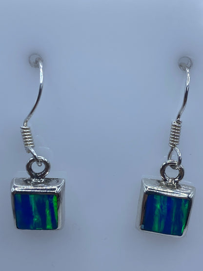 Detalle de un arete mostrando el engaste a mano de la piedra de ópalo en plata