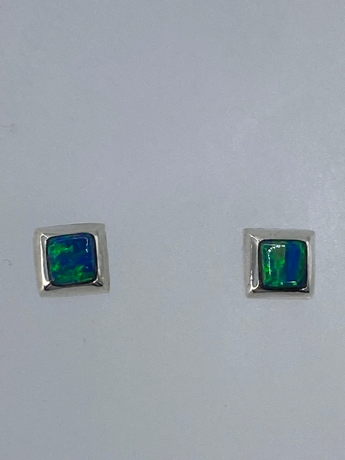 Aretes minimalistas sobre fondo blanco con Quinto 925 visible