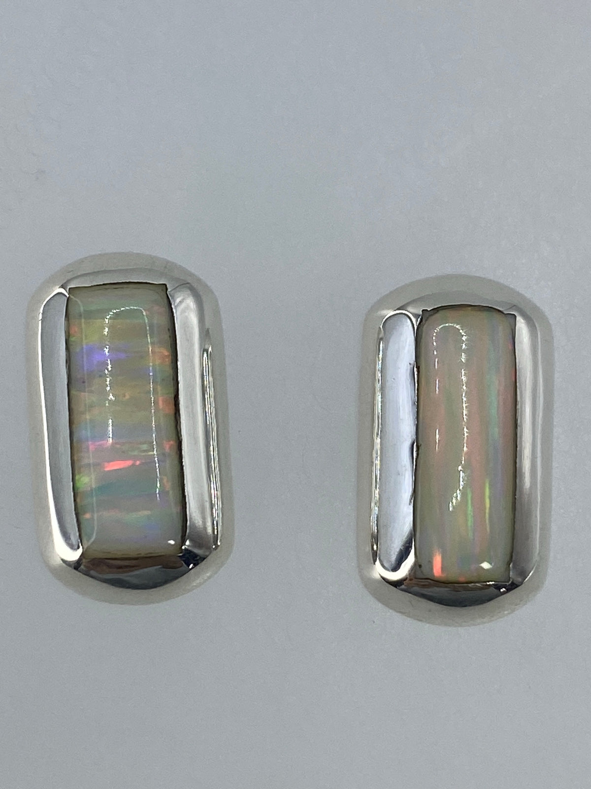 Aretes pequeños de 1.3 cm delante de una regla para escala