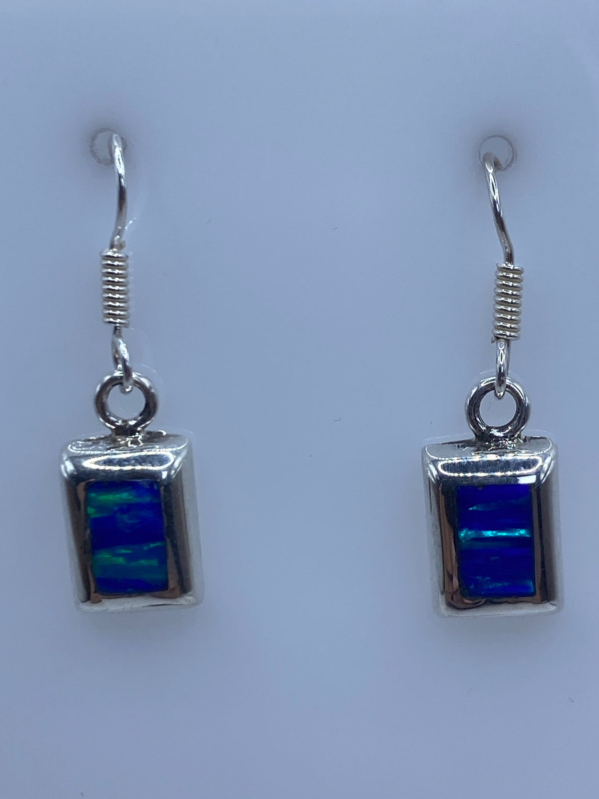 Par de aretes de plata con ópalo de fuego azul de 3.4 cm en gancho, vista frontal simétrica