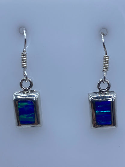 Par de aretes de plata con ópalo de fuego azul de 3.4 cm en gancho, vista frontal simétrica
