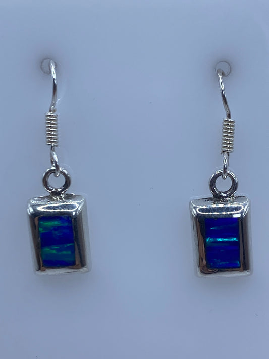 Par de aretes de plata con ópalo de fuego azul de 3.4 cm en gancho, vista frontal simétrica