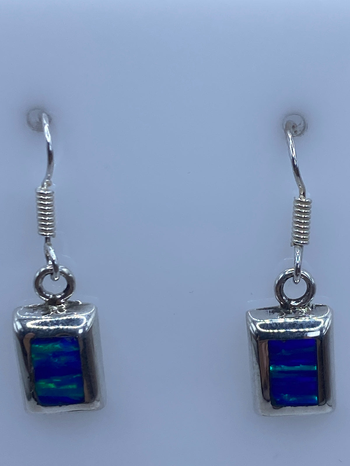 Detalle del engaste a mano del ópalo en plata 925, mostrando el fuego azul bajo la luz