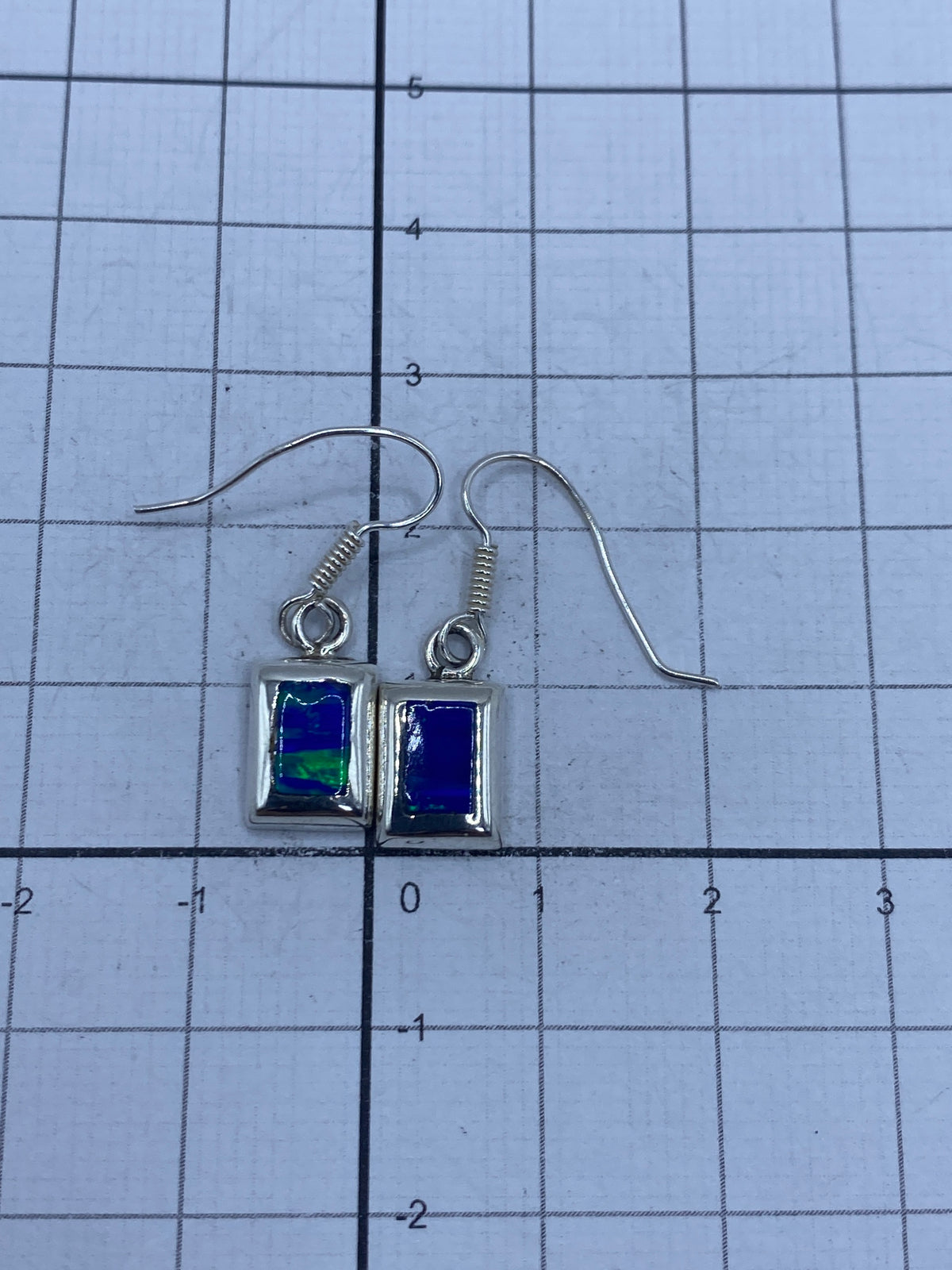 Aretes en la balanza mostrando peso de 1.6 g el par, con sello SKU