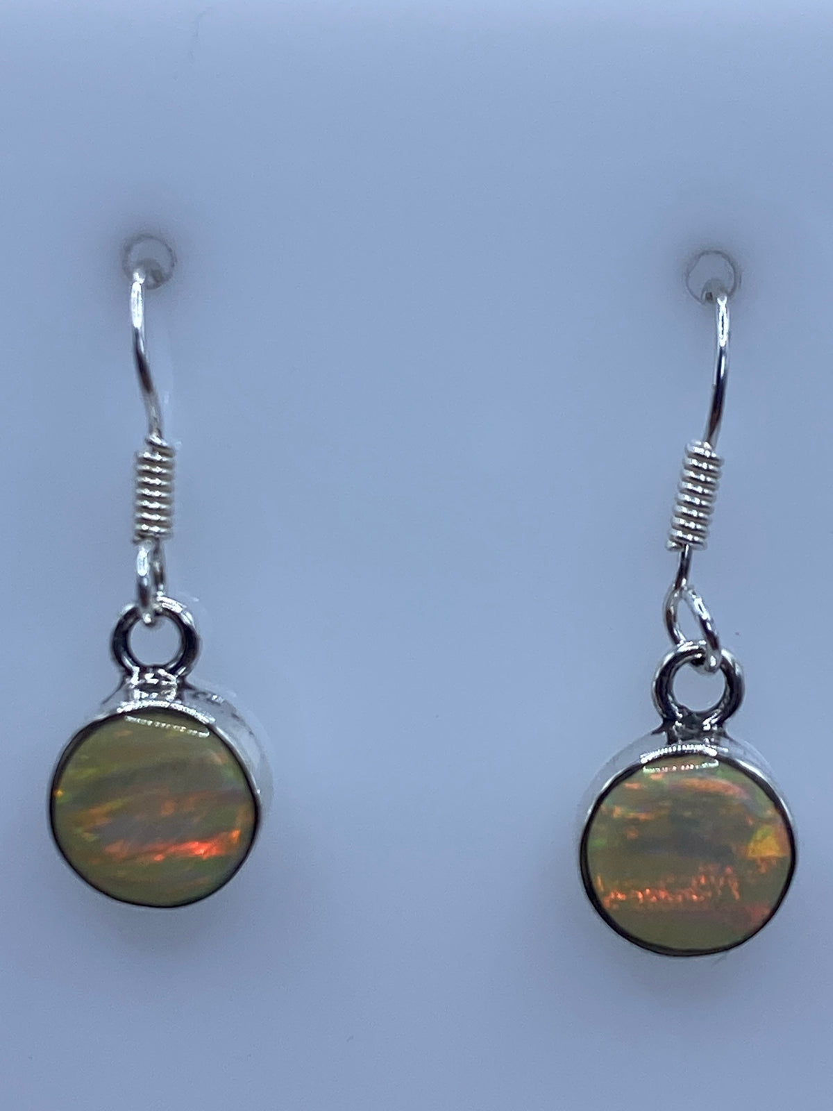 Aretes de ópalo de fuego en escala, midiendo 2.3 cm de largo