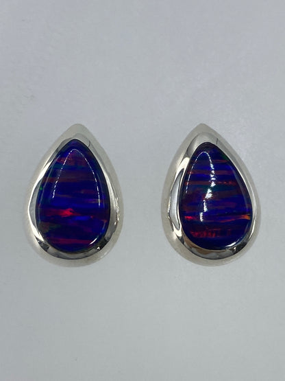 Detalle de un arete mostrando el engaste de plata y el fuego del ópalo