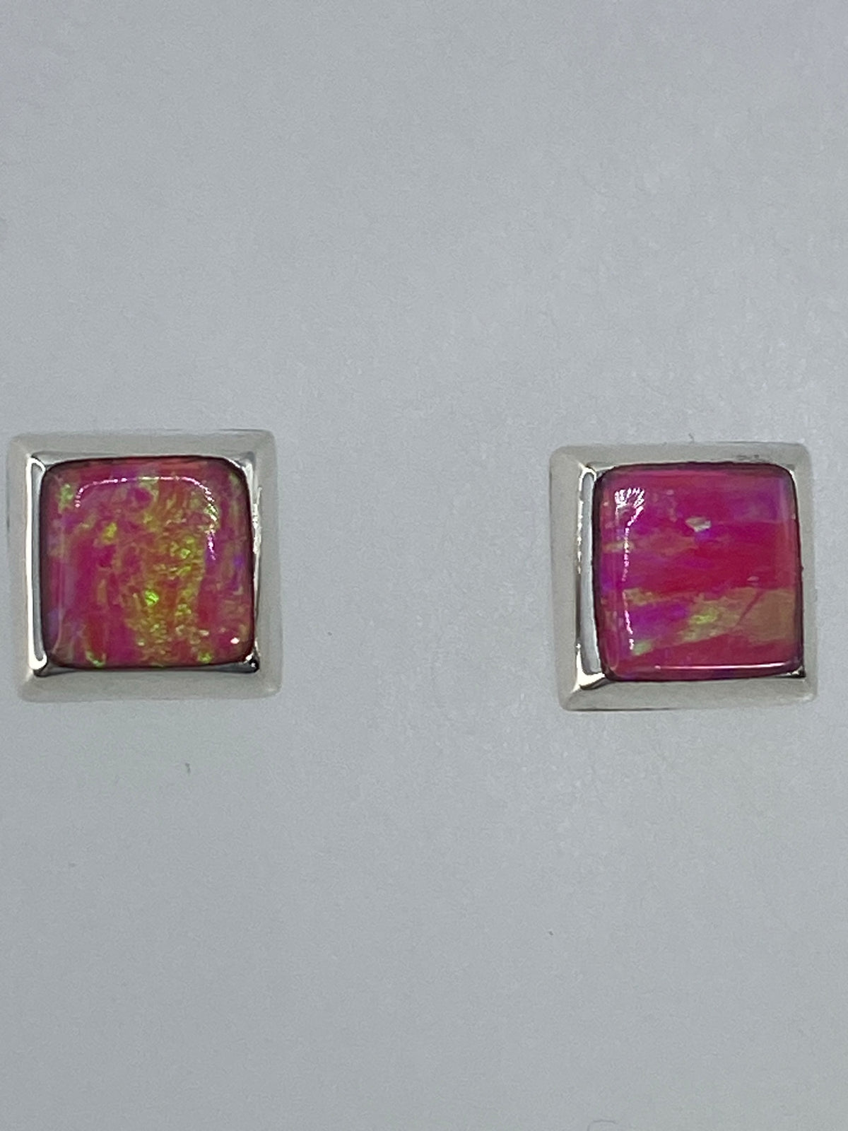 Detalle de los aretes mostrando el juego de colores del ópalo de fuego